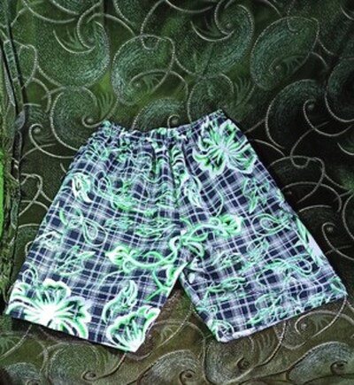 Новые мужские короткие шорты в чёрно-белую клетку с зелёным орнаментом.