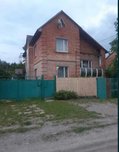 Міцний двоповерховий цегляний будинок.